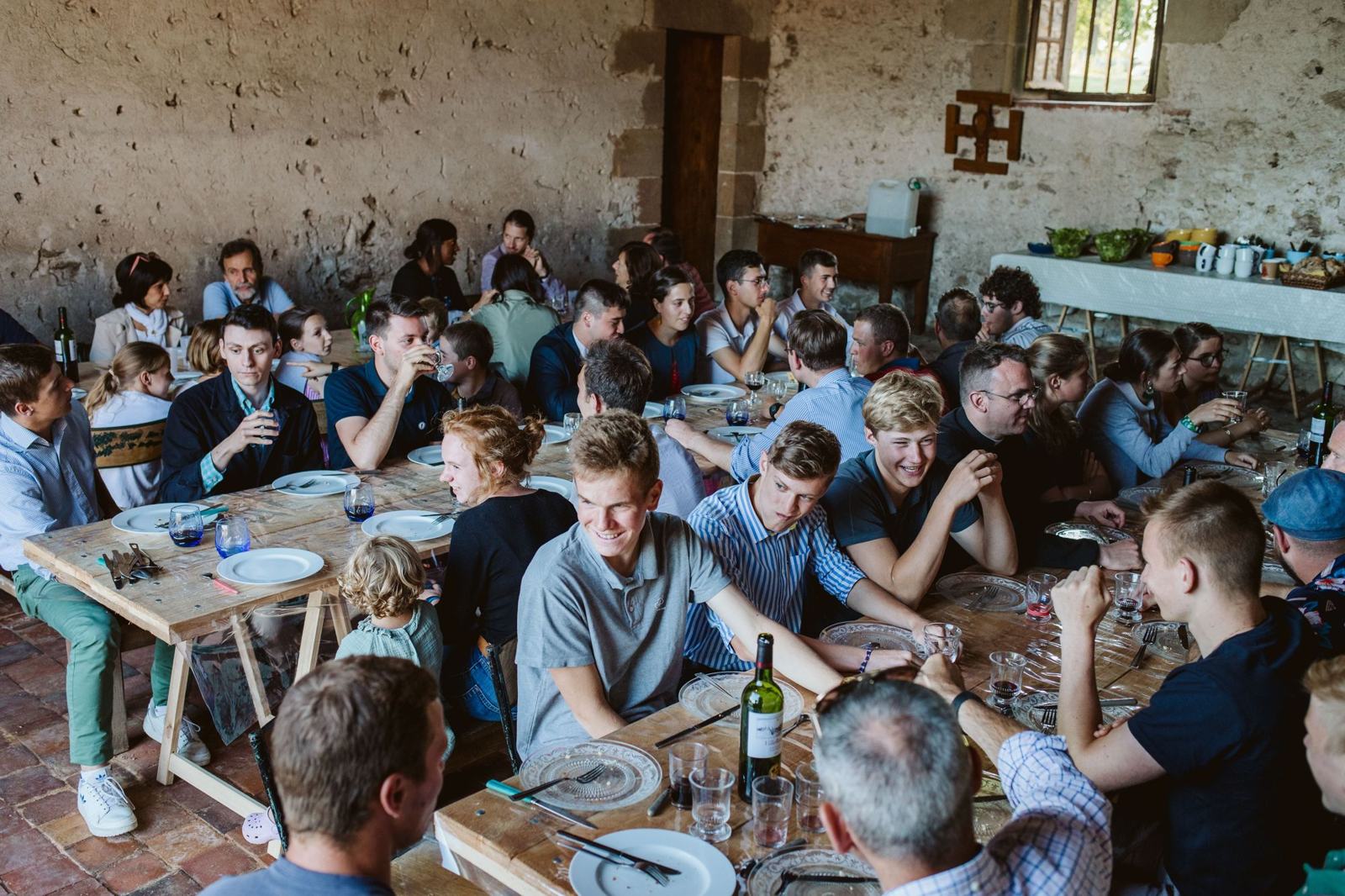 Repas partagé entre participants dans une grange